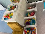 plusieurs bacs remplis de jouets dans un coin de la pièce