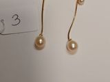 a pair of pearl earrings on a white surface