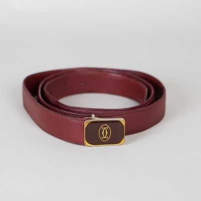 un gros plan d'une ceinture rouge avec une boucle dorée