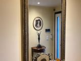 a mirror on the wall above a table with a clock on it