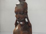 statue d'une femme portant une plume et un chapeau sur la tête