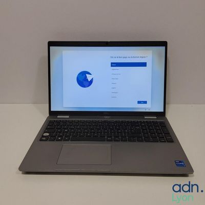 un ordinateur portable ouvert posé sur une table blanche