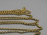a close up of a gold chain on a gray surface