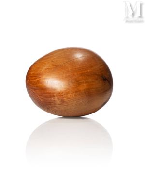 a wooden egg that is sitting on a white surface