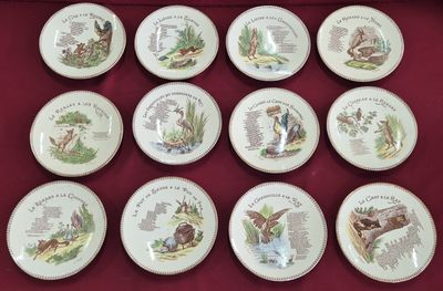 six assiettes ornées de différentes illustrations d'animaux, posées sur une nappe rouge