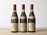trois bouteilles de vin posées sur une table en bois