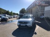 the white car is parked in front of a building with a lot of cars parked in front of it