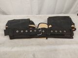 a pair of black leather holsters sitting on top of a bed