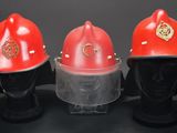 three red fire helmets are lined up against a black background