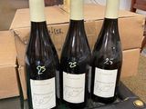 three bottles of wine sitting on a table next to a box of wine