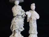 paire de figurines en porcelaine blanche représentant une femme et un homme avec une ombrelle