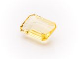 a yellow sapphire stone on a white background
