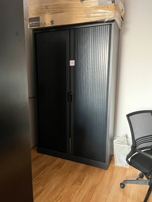 une chaise noire devant une armoire noire et une chaise noire