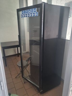 a black refrigerator with a glass door in a kitchen