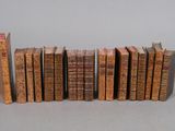 several old books lined up in a row on a gray surface