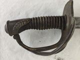 a close up of a sword on a white surface
