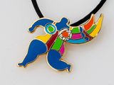 pendentif en forme d'oiseau aux couleurs vives, suspendu à un collier à cordon noir, posé sur une surface blanche