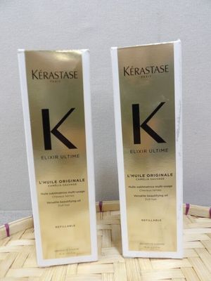 two bottles of kerastasee hair oil sitting on top of a basket
