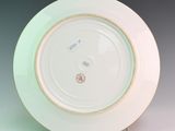 a white plate with a green rim on a white table