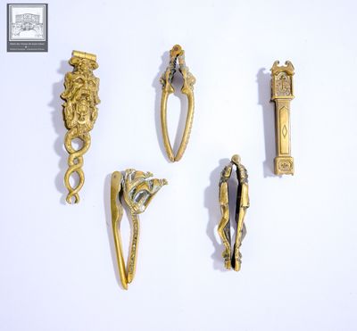 quatre bijoux en or et en argent posés sur un fond blanc