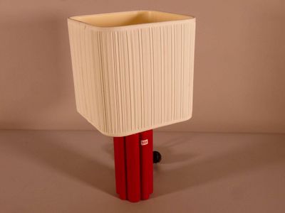 a lamp that is sitting on a table with a red base