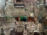 a glass display case filled with glass vases and glasses