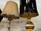 deux lampes posées sur une étagère en verre dans une pièce