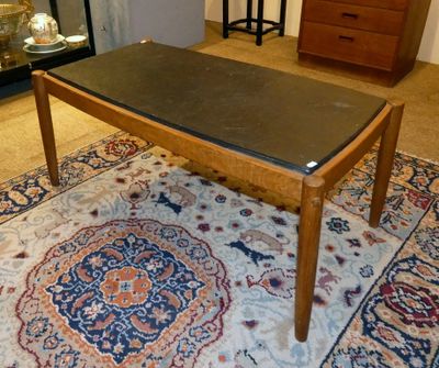 une table au plateau noir posée sur un tapis dans un salon