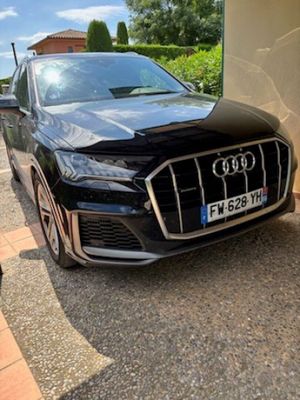 Le SUV Audi noir est garé devant un immeuble.