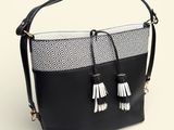 a black and white bag with tassels on top of it
