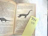 a person holding a book with an image of a dinosaur on it
