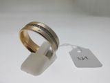 gros plan d'une bague sur une surface blanche avec une étiquette de prix