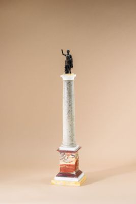 statue of a man holding a staff on top of a column