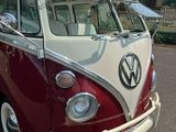 un minibus Volkswagen rouge et blanc garé sur un parking
