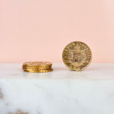 two gold coins sitting on top of a marble counter top