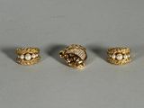 three gold tone rings with pearls and leaves on them