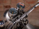 gauges on the handlebars of a motorcycle with a brick wall in the background