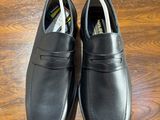 pair of men ' s black leather shoes on a wooden table