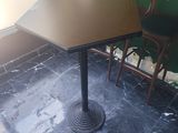 une table et des chaises dans un restaurant, avec une enseigne accrochée au mur