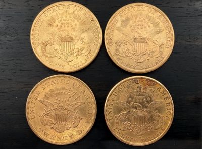 quatre pièces d'or posées sur une table en bois