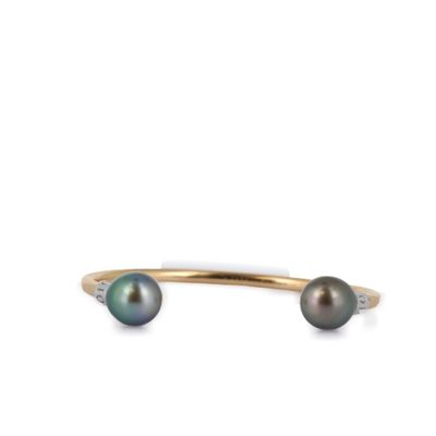 un gros plan d'un bracelet manchette orné d'une perle noire et de diamants