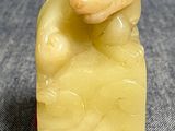 une petite statue représentant un singe assis sur un rocher