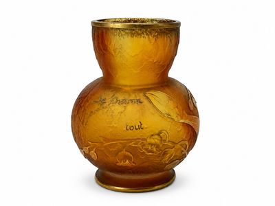 un vase jaune orné d'une inscription, posé sur une table
