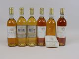 six bottles of wine sitting next to each other on a white surface