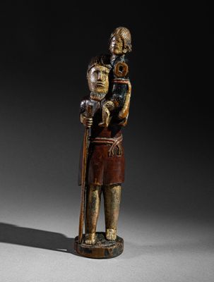 une image représentant une statue en bois d'un homme tenant un enfant dans ses bras
