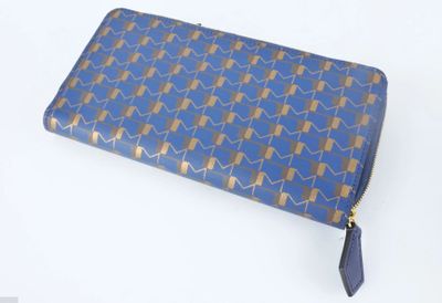 sac à main à motifs bleus et dorés, orné de pompons et d'un pompon