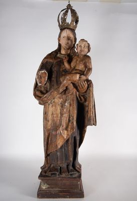 une vieille statue en bois représentant une femme tenant un enfant dans ses bras
