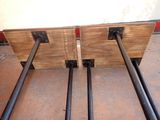 two pieces of wood with black pipes attached to them