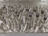 silverware in a silver box with a silver handle and silver spoons