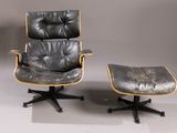 an image of a black leather chair and ottoman on a grey background